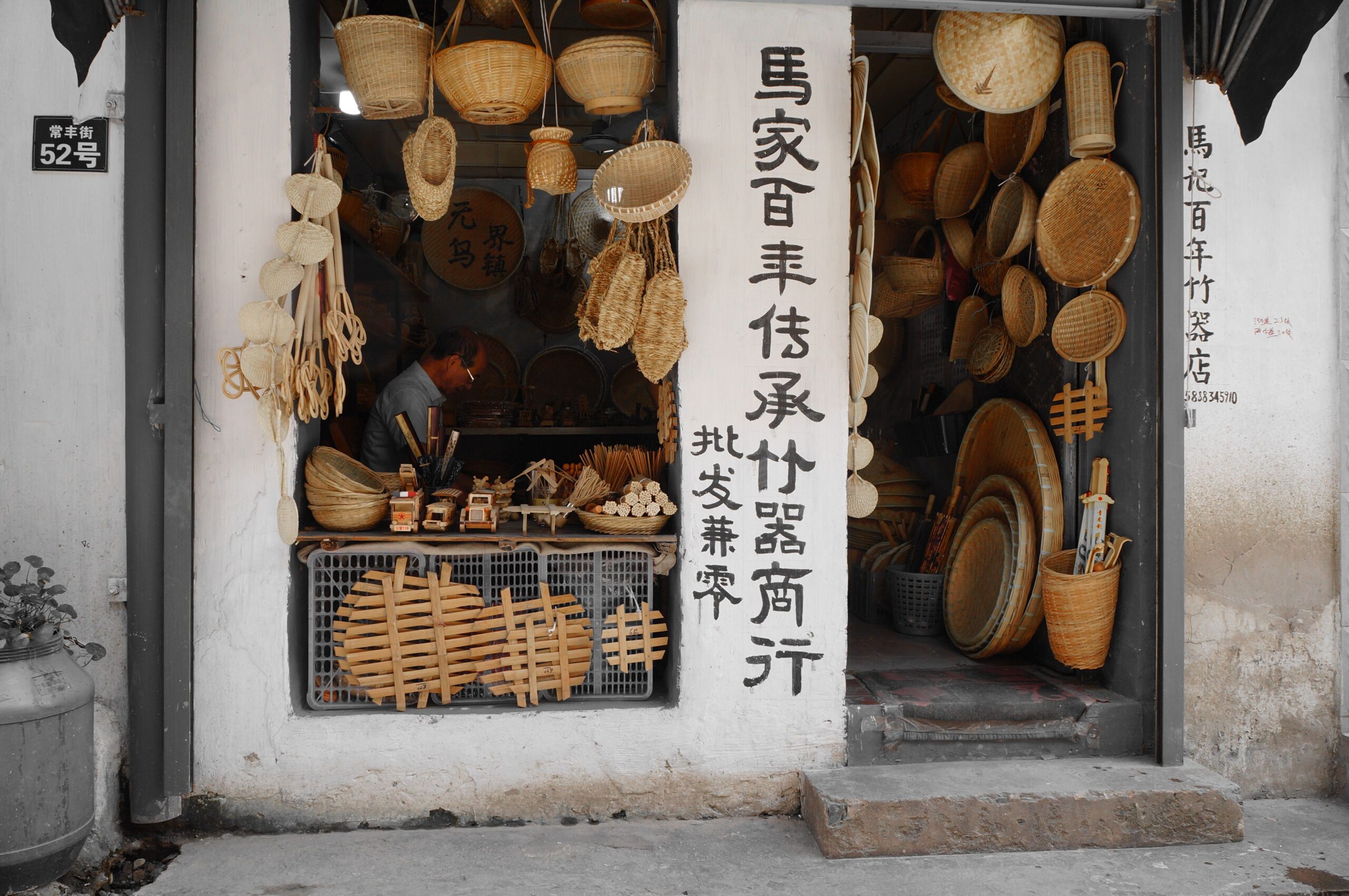 Explore a rural Asian shop showcasing traditional bamboo and wicker crafts, with cultural inscriptions.