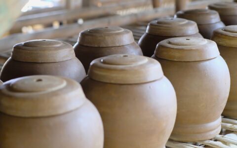 Close-up of traditional clay pots in a rustic West Java workshop setting.