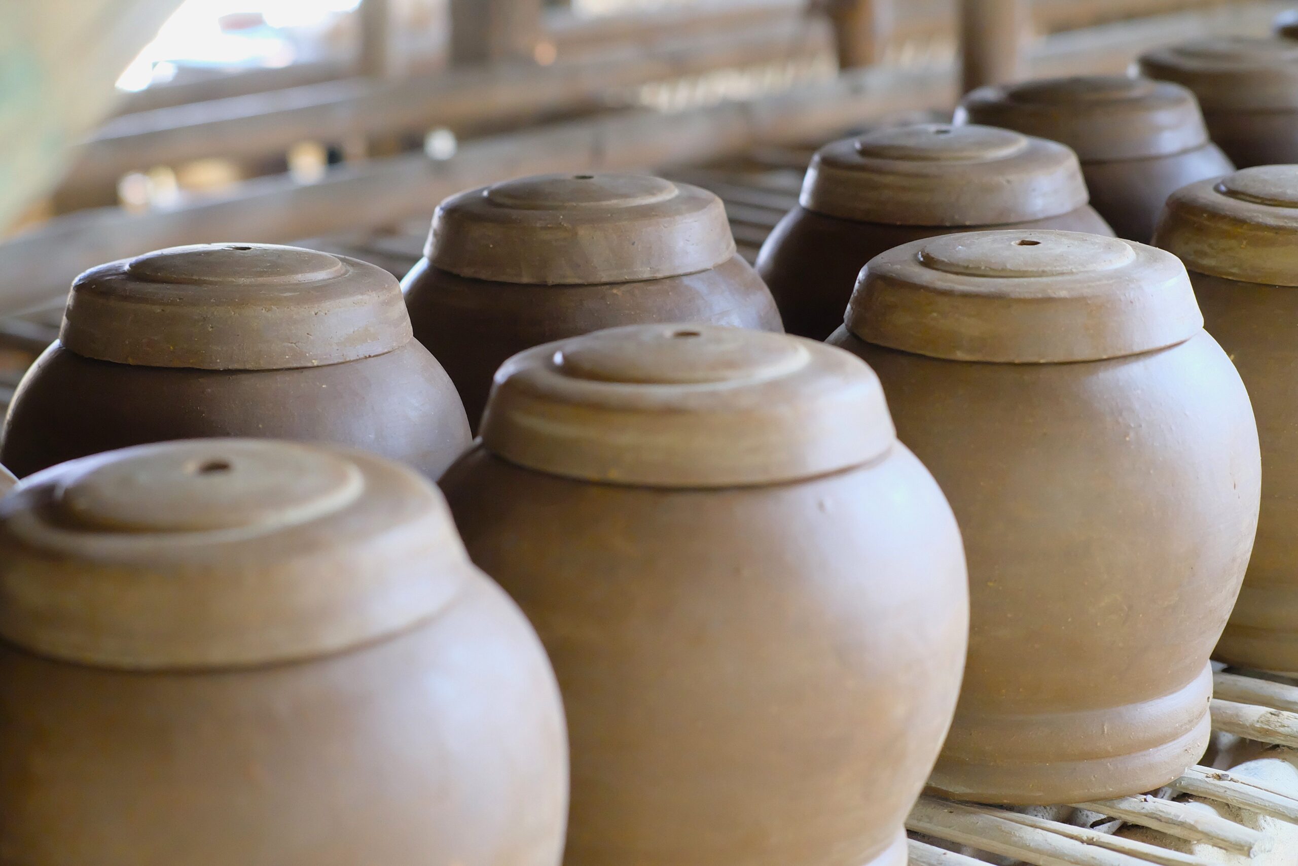Close-up of traditional clay pots in a rustic West Java workshop setting.