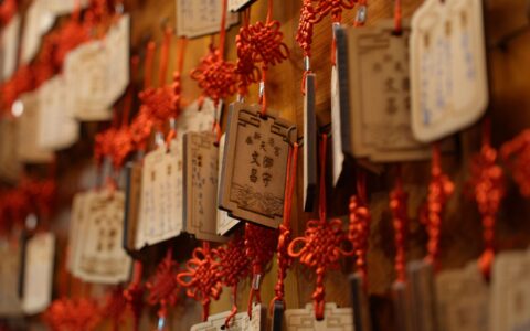 Hanging wooden prayer plaques with red knots in Chiayi County, Taiwan, symbolizing cultural heritage.